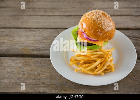 Erhöhte Ansicht der Burger mit Pommes frites serviert in Platte auf Holztisch Stockfoto