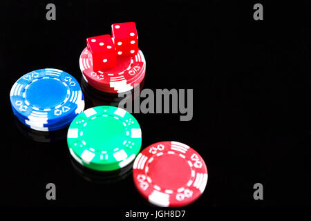 Erhöhte Ansicht der rote Würfel mit Chips auf schwarzem Hintergrund Stockfoto
