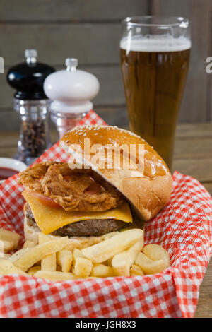Burger und Pommes frites im Korb auf Holztisch Stockfoto