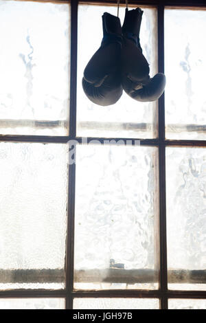 Paar Boxhandschuhe hängen am Fenster im Fitness-studio Stockfoto