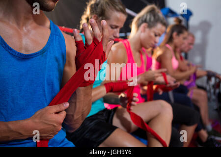 Reihe von Athleten, die Umhüllung Bandagen auf Händen im Fitness-studio Stockfoto