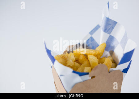 Nahaufnahme von Pommes frites im Karton auf Tisch Stockfoto