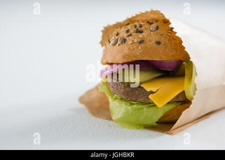 Nahaufnahme eines Hamburger in Papiertüte auf weißen Tisch Stockfoto