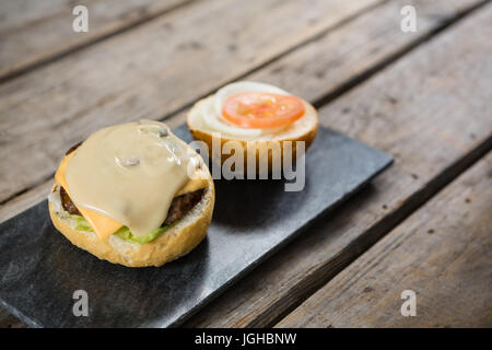 Erhöhte Ansicht-Sauce mit Käse und Fleisch auf Brötchen Stockfoto