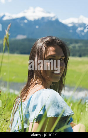 Porträt des Lächelns schön sitzen auf dem Rasen Stockfoto