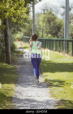 Rückseite Blick voller Länge Sportlerin läuft Weg Stockfoto