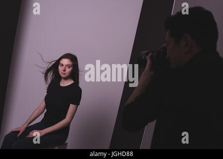 Mann Fotografieren weibliches Modell vor Hintergrund im studio Stockfoto