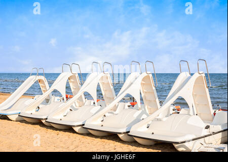 Weiße Reihe von Pedalo geparkt am Strand. Stockfoto