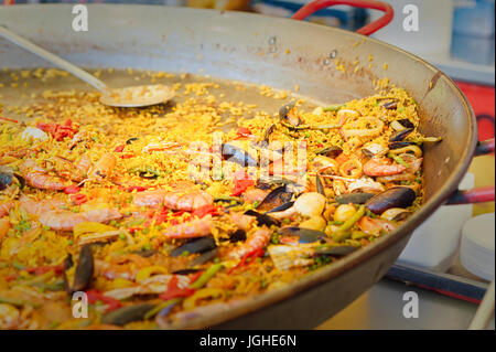 Meeresfrüchte-Paella in einer Paellapfanne auf eine Straße Lebensmittelmarkt traditionelle spanische Paella mit Meeresfrüchten und Hähnchen. Stockfoto