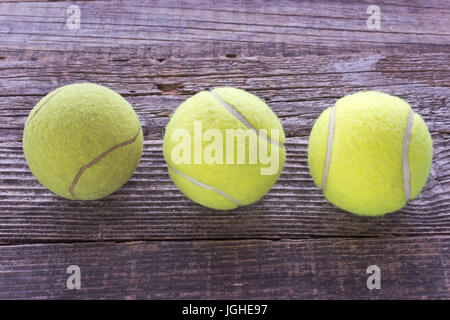 Drei verwendet Tennisbälle auf hölzernen Hintergrund Stockfoto