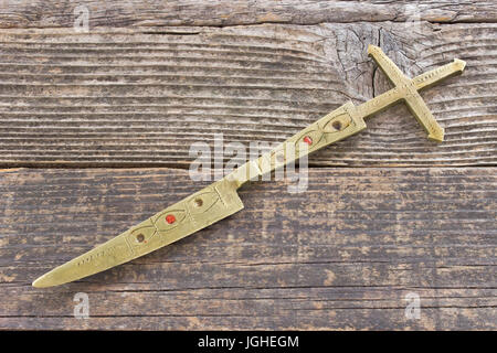 Messing Brief Öffner Messer mit Kreuz auf hölzernen Hintergrund Stockfoto