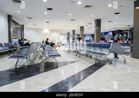 CAMPO GRANDE, Brasilien - 14. Juni 2017: Einige Leute warten auf Abfahrt und ein paar leere Stühle auf Abflug-Lounge der Aeroporto Internacional de Campo Stockfoto