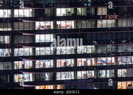 Bürogebäude, in der Nähe von Fenstern auf der Seite der schwarzen in der Nacht, mit verschiedenen Büros und Windows Mit arbeiter in Osaka, Japan beleuchtet. Stockfoto