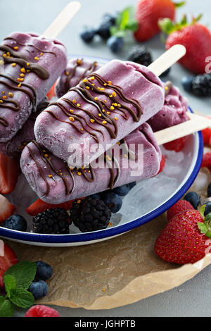 Gemischte Beeren Eis am Stiel mit Schokoladenglasur Stockfoto