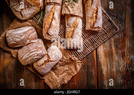 Zusammensetzung des weißen ganze Brote und Baguettes in Packpapier eingewickelt Stockfoto