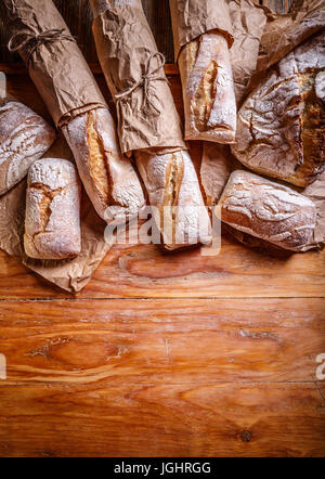 Frisch gebackene leckere Brote auf einem hölzernen Hintergrund mit Textfreiraum Stockfoto