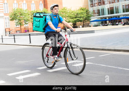 Kurier am Fahrrad liefern Nahrung In Stadt Stockfoto
