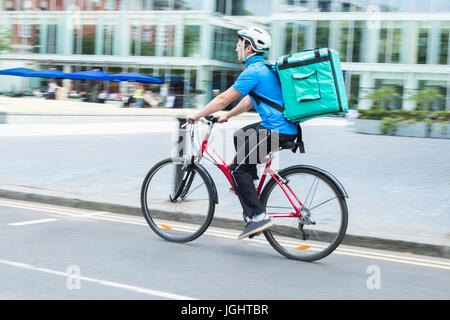 Kurier am Fahrrad liefern Nahrung In Stadt Stockfoto