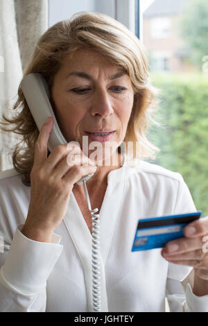 Reife Frau geben Kreditkarten-Daten auf dem Handy Stockfoto