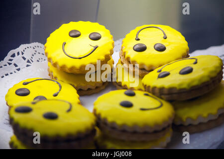 Hausgemachte Kekse mit fröhlichen Smileys auf einer weißen Platte Stockfoto