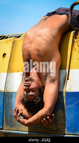 Junge indische Arbeiter Yoga Übung bei entspannenden Stunden in Baustelle Stockfoto