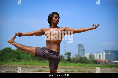 Junge indische sportlichen Mann tut Yoga-Übung im Park. Stockfoto