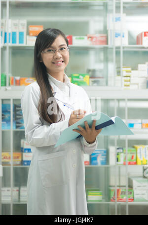Porträt einer lächelnden medizinisches Personal oder Arzt im Krankenhausapotheke. Ziemlich Asian Woman. Stockfoto