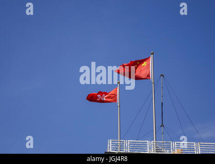 China und Hong Kong Fahnen schweben auf der Oberseite Regierungsgebäude in Hong Kong. Stockfoto