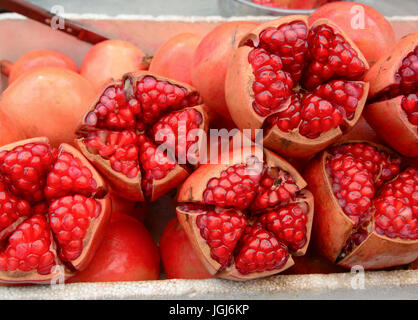 Draufsicht der Reifen Granatapfel Früchte aufplatzen, Cluster von Samen zu offenbaren. Zum Verkauf in Thailand Frischmarkt. Stockfoto
