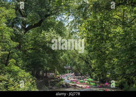 Sommer-Tubing am Chattahoochee River unter einem Baldachin von Bäumen durch die Innenstadt von Helen, Georgia. (USA) Stockfoto