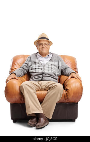 Älterer Mann sitzt in einem Ledersessel und schaut in die Kamera, die isoliert auf weißem Hintergrund Stockfoto