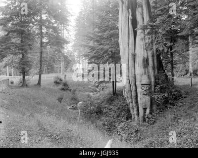 Stanley Park, Vancouver - Totemfigur durch einen Baum, Stanley Park Stockfoto