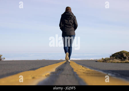 Die Frau auf der Straße über den Wolken am Haleakala National Park auf der hawaiianischen Insel Maui Stockfoto