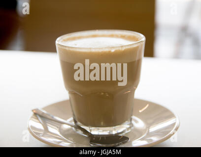 Tasse Kaffee mit Milch über Holztisch Stockfoto