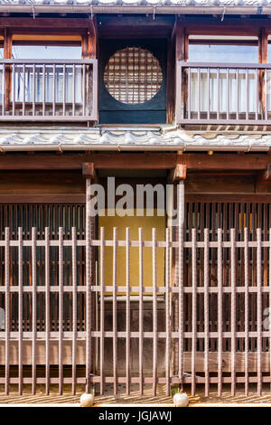Japan, Tatsuno. Eingang japanisches Haus mit traditionellen Gittertyp Zaun außen und Balkon mit kleinen Gitter Rahmen vor den Fenstern. Stockfoto