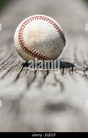 Eine abgenutzte weiße Baseball auf einem verwitterten bleicher-Bank Stockfoto