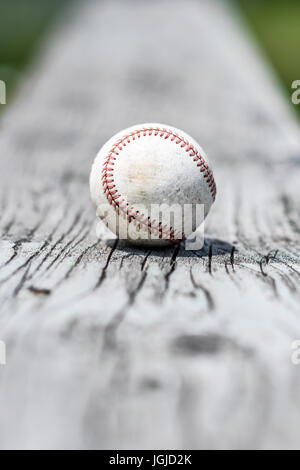 Eine abgenutzte weiße Baseball auf einem verwitterten bleicher-Bank Stockfoto