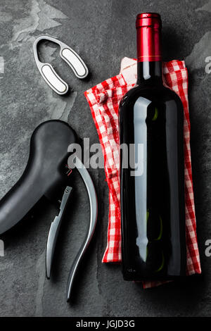 Flasche Rotwein mit Korkenzieher auf schiefer Hintergrund. Ansicht von oben Stockfoto