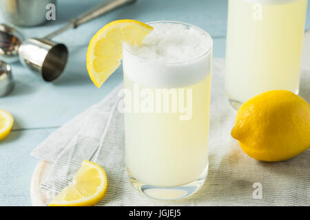 Erfrischende kalte Ei Gin Fizz mit einer Zitrone garnieren Stockfoto