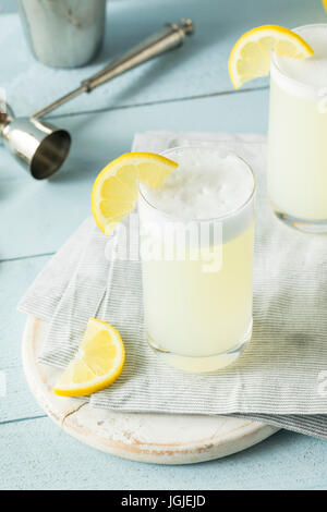 Erfrischende kalte Ei Gin Fizz mit einer Zitrone garnieren Stockfoto