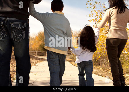 Rückansicht einer glücklichen Familie spazieren. Stockfoto