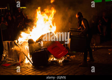 Hamburg, Deutschland. 6. Juli 2017. St. Pauli/Hamburg - Deutschland 6. Juli 2017: Evangelische in eine brennende Straße Blockade vor der "Roten Flora" eine Mülltonne zu werfen. Bildnachweis: Eva Agata Draze/Alamy Live-Nachrichten Stockfoto