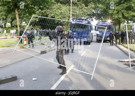 Hamburg, Deutschland. 7. Juli 2017. Ein Polizist trägt einen Zaun in Hamburg, Deutschland, 7. Juli 2017. Die Regierungschefs der G20-Gruppe von Ländern treffen sich am 7. / 8. Juli 2017 in Hamburg. Foto: Bodo Marks/Dpa/Alamy Live News Stockfoto