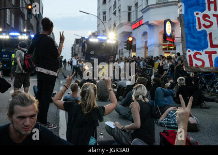 Hamburg, Deutschland. 7. Juli 2017. Deutschland, Hamburg, Protestkundgebung auf der Reeperbahn in St. Pauli gegen G20-Gipfel im Juli 2017, sitzen Demonstrant vor Polizei Wasserwerfer/DEUTSCHLAND, Hamburg, St. Pauli, Protest-Demo Auf der Reeperbahn Gegen G20 wurde in Hamburg, Sitzblockade Vor Wasserwerfern der Polizeistation Davidwache Credit: Joerg Boethling/Alamy Live News Stockfoto