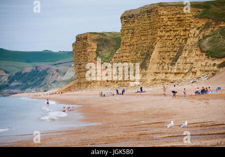 Burton Bradstock, Dorset, UK. 8. Juli 2017. Menschen am Strand mit den berühmten Klippen von West Bay als Kulisse genießen, wie die sonnige warme Wetter an der Südküste weiter. Bildnachweis: Dan Tucker/Alamy Live-Nachrichten Stockfoto