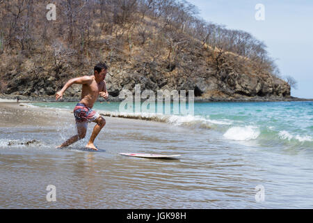 junger Mann skim Boarding in Playa Calzon de Pobre, Costa Rica an einem schönen sonnigen Tag. Stockfoto