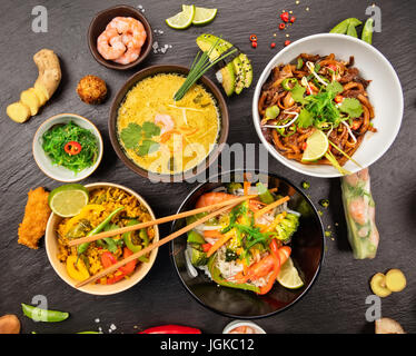 Asiatische Lebensmittel-Tabelle mit verschiedenen Arten von chinesisches Essen, Nudeln, Huhn, Schwein, Rind, saure Suppe, Reis, Frühlingsrollen, Sushi, Garnelen und viele andere. Serviert Stockfoto