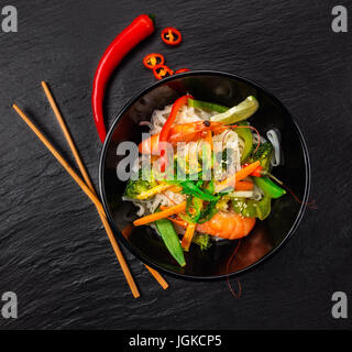 Asiatischen Huhn und Garnelen curry mit Reis, Draufsicht, serviert auf schwarzem Stein. Stockfoto