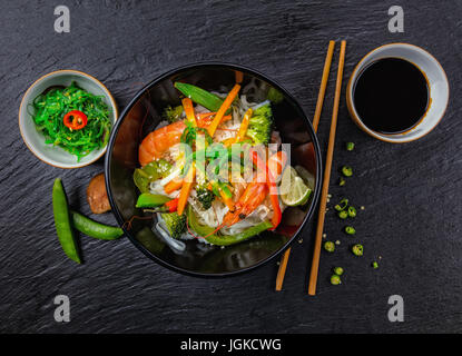 Asiatischen Huhn und Garnelen curry mit Reis, Draufsicht, serviert auf schwarzem Stein. Stockfoto