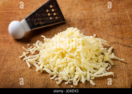 Nahaufnahme von frisch geriebener Parmesan-Käse auf Holztisch Stockfoto